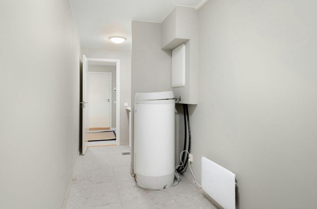 Technician repairing leaking basement water heater during urgent East York household hot water outage