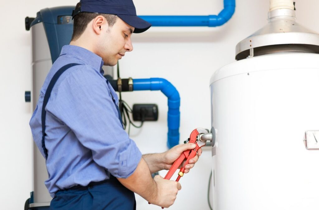 Technician repairing faulty water heater controls in Etobicoke basement utility room